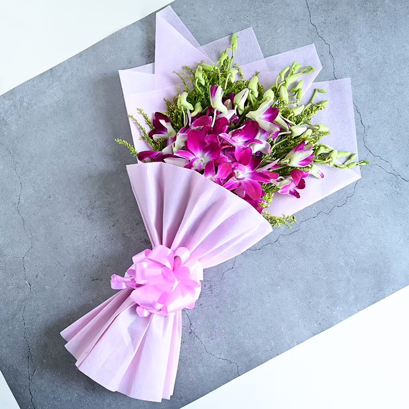 Purple Orchids in Pink Paper Packaging